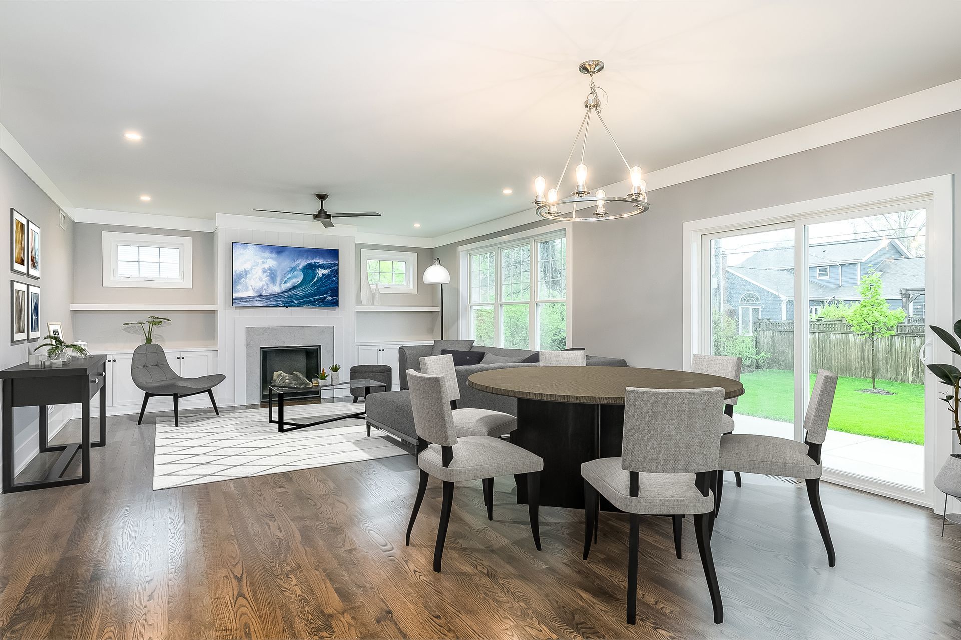 Open-concept living and dining room with fireplace, dining table, and sliding glass door to backyard.