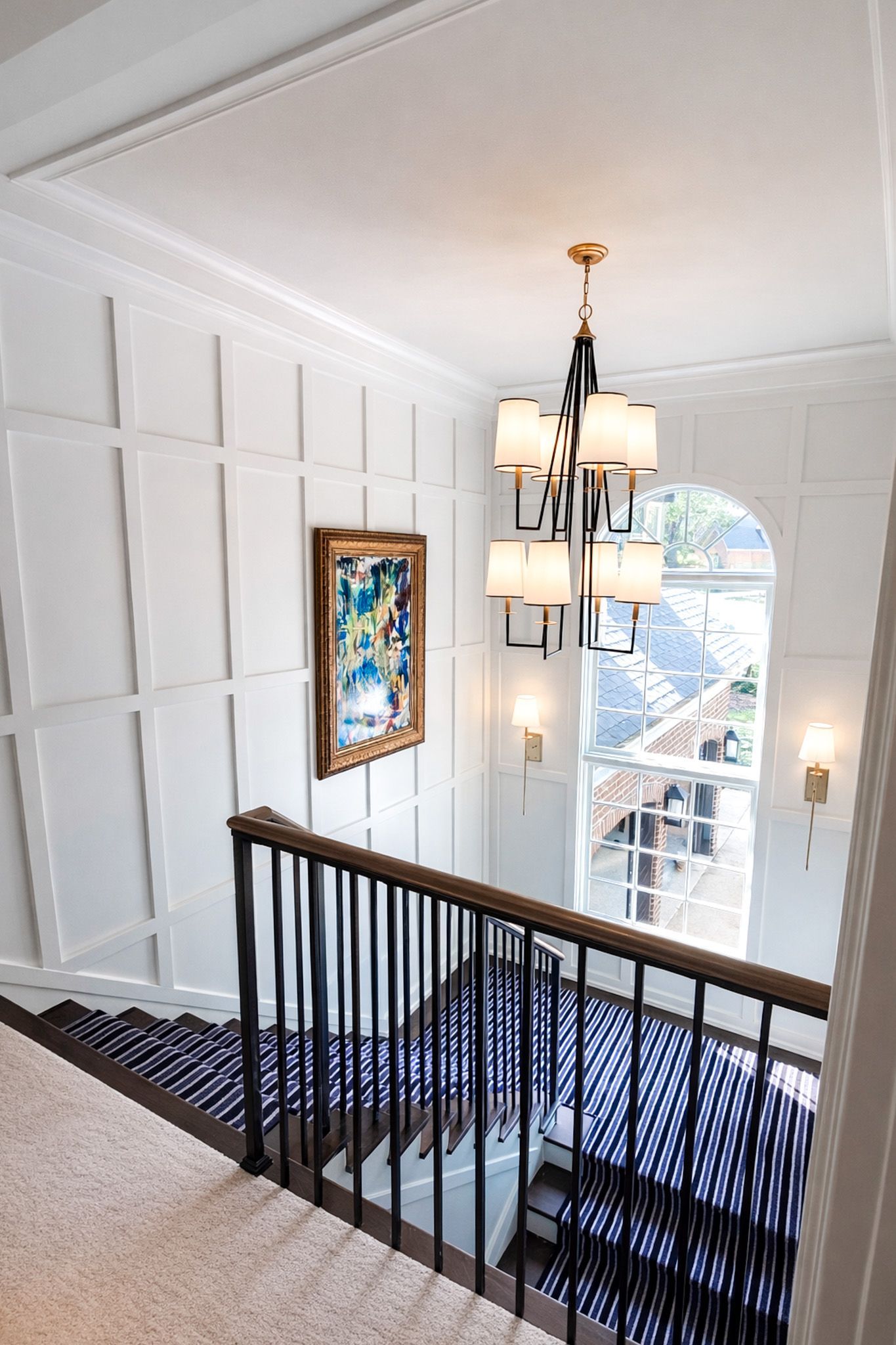 White kitchen with island, wooden beams, and stainless steel appliances.