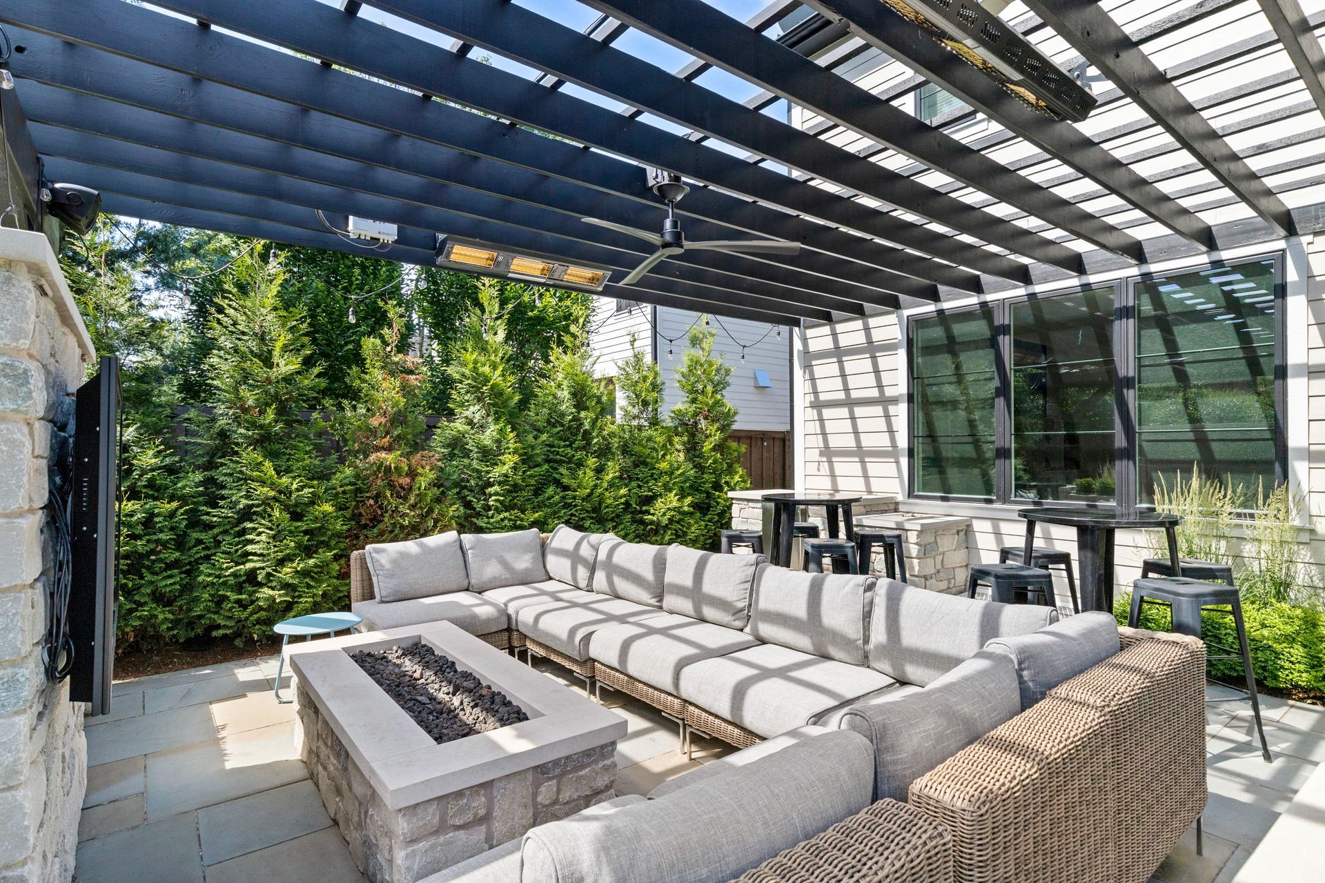 Outdoor patio with a sectional sofa, fire pit, and pergola.