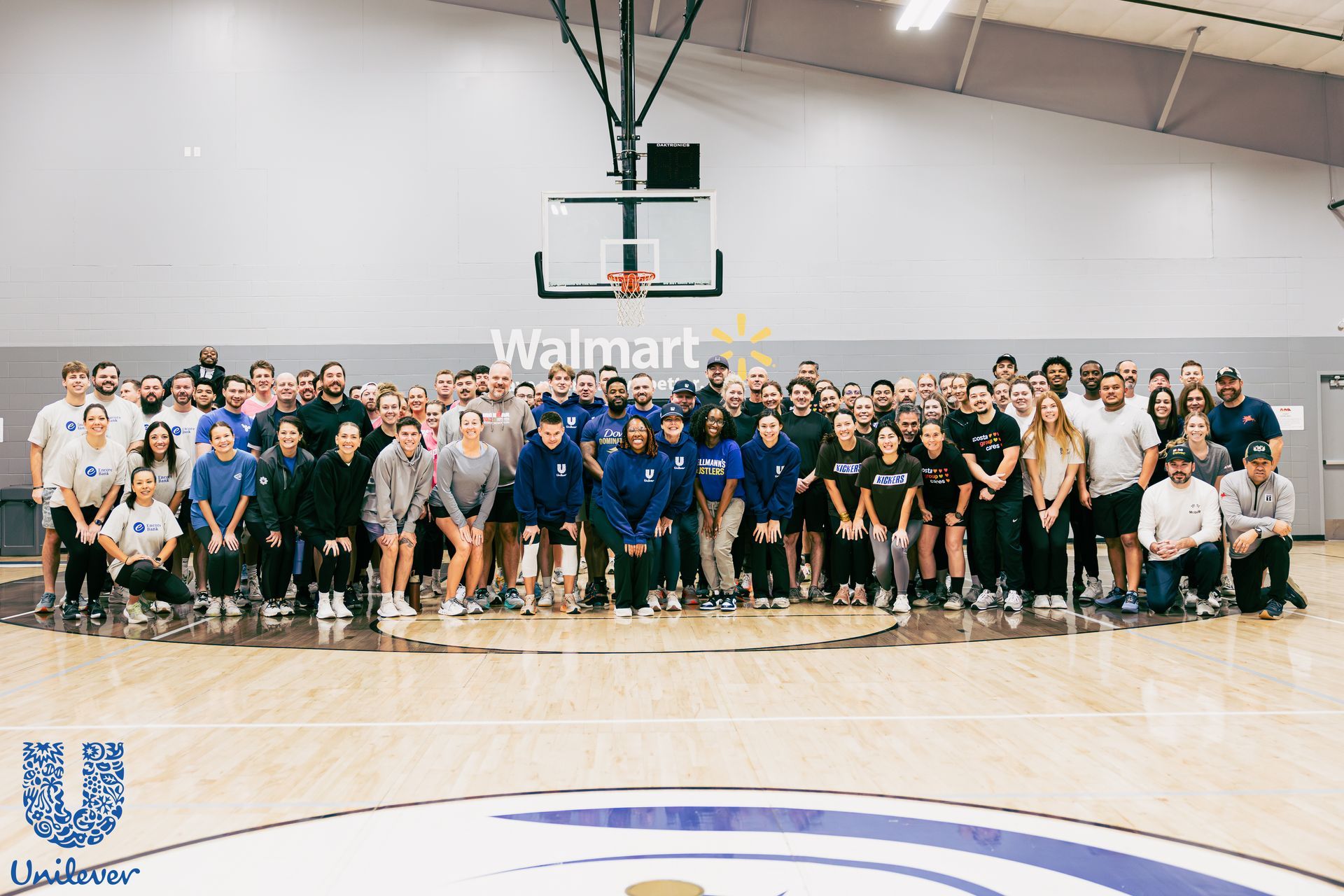 Two young basketball players jumping to shoot the ball. One in red, one in black. Indoor court.