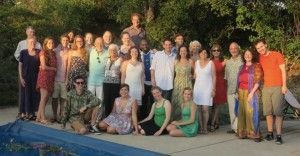 A large group of people are posing for a picture in front of a pool.