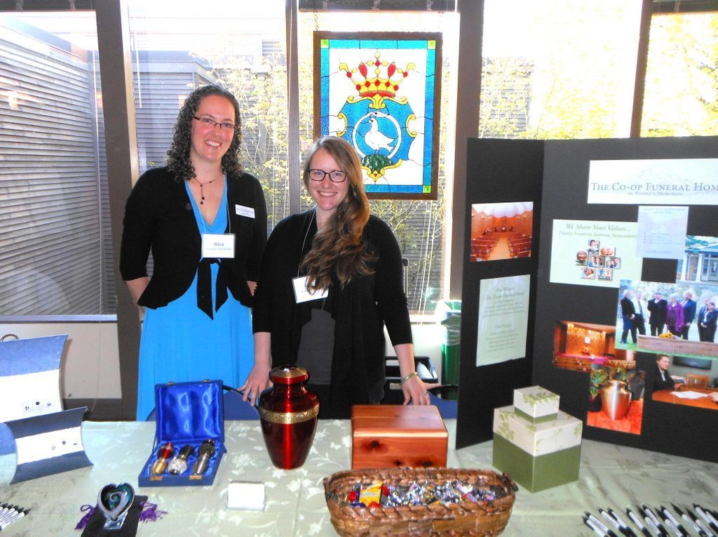 Two women standing in front of a table with a urn on it