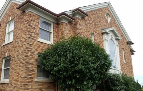 A brick building with a tree in front of it