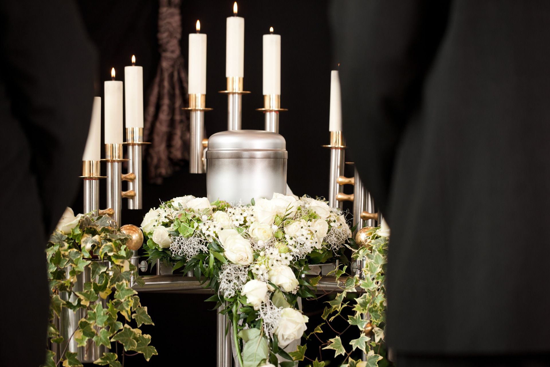 A urn surrounded by flowers and candles at a funeral