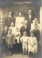 A black and white photo of a large family posing for a picture.