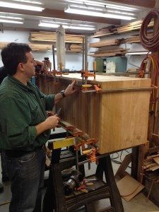 A man is working on a piece of wood in a workshop.