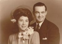 A man and a woman are posing for a picture together in a black and white photo.