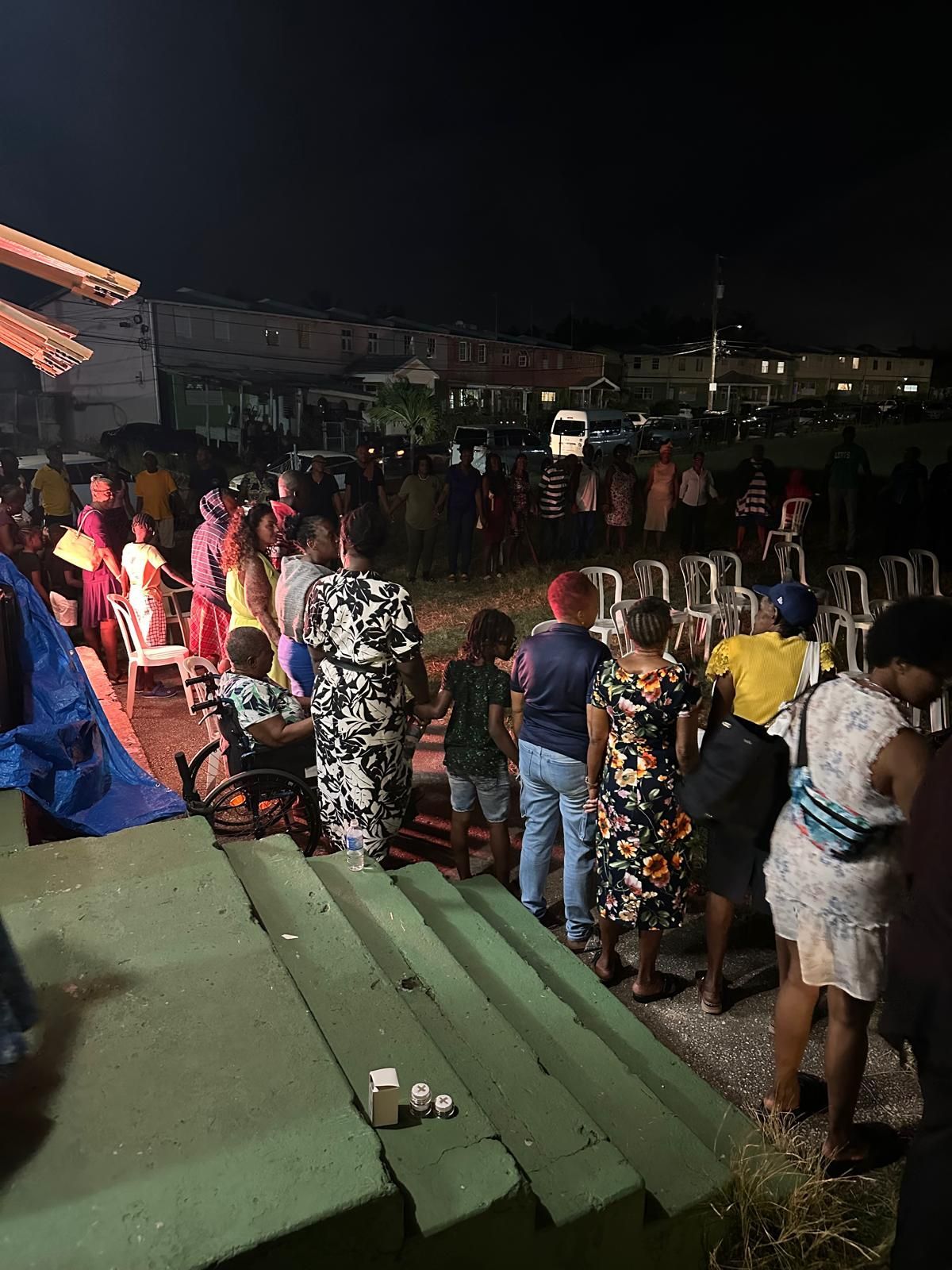 A group of people are standing on a set of stairs at night.