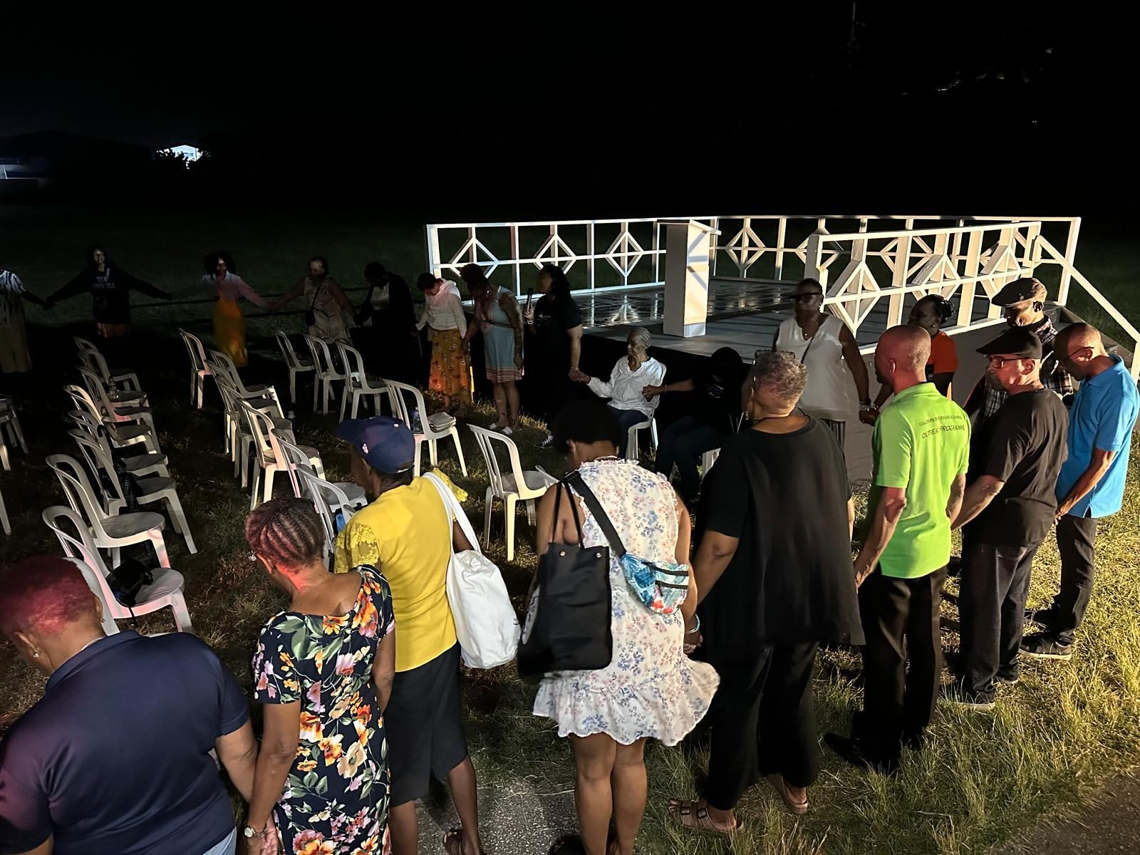 A group of people are standing in a field at night.