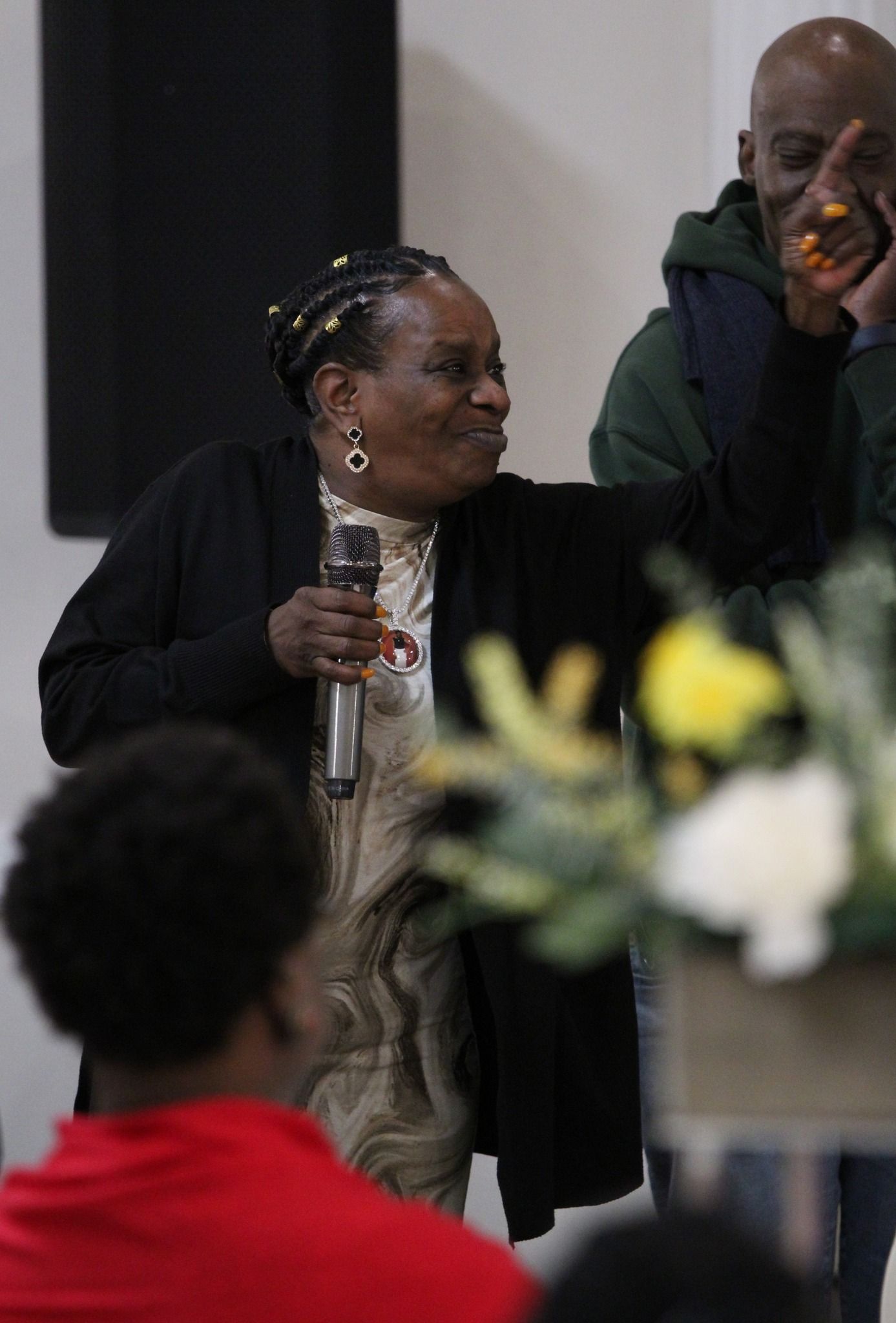 A woman is holding a microphone while standing next to a man