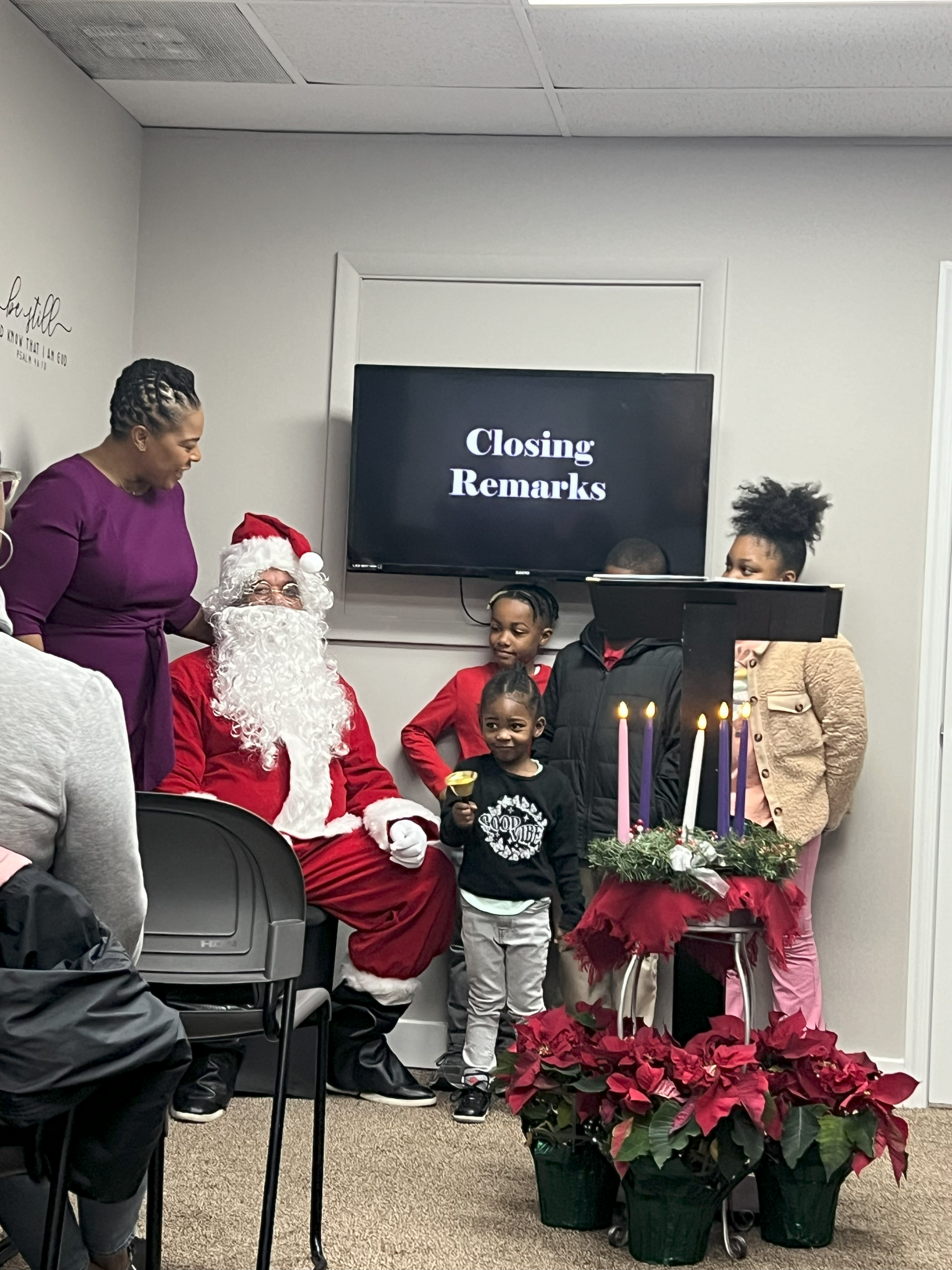 A group of people are sitting in a room with santa claus.