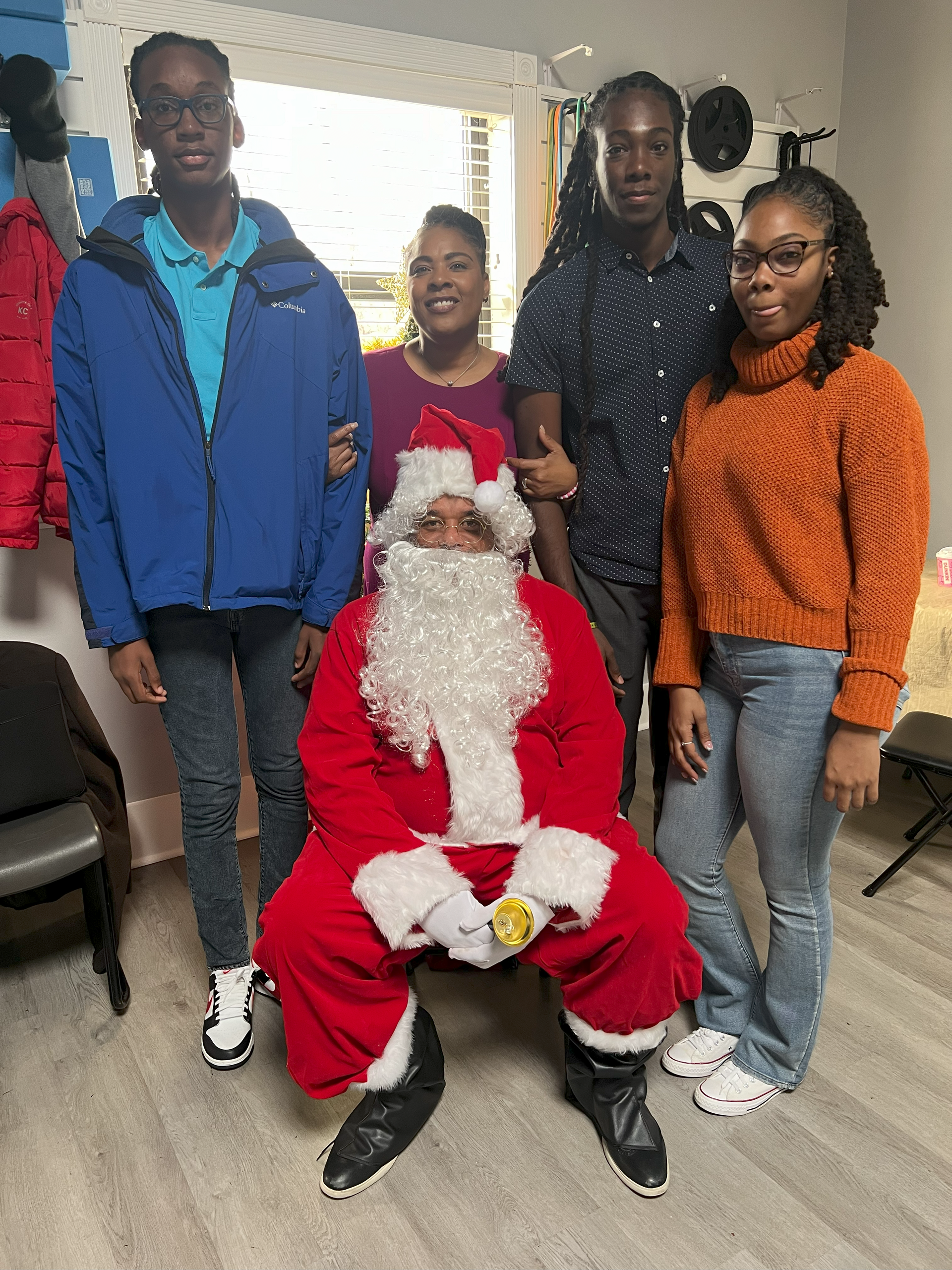 A group of people are posing for a picture with santa claus.