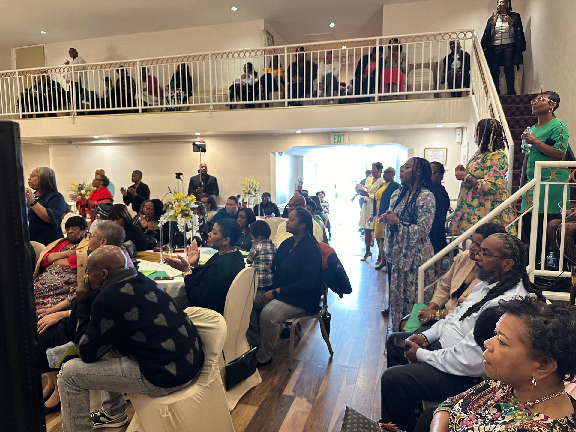 A large group of people are sitting at tables in a room.