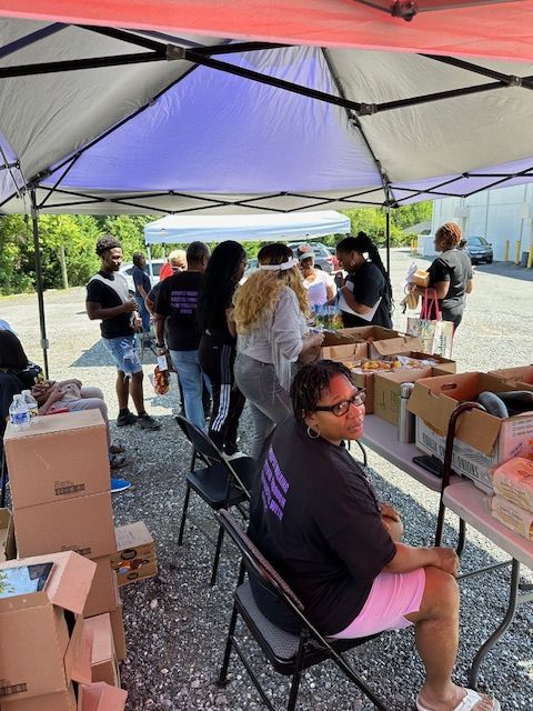 A woman is sitting at a table under a tent.