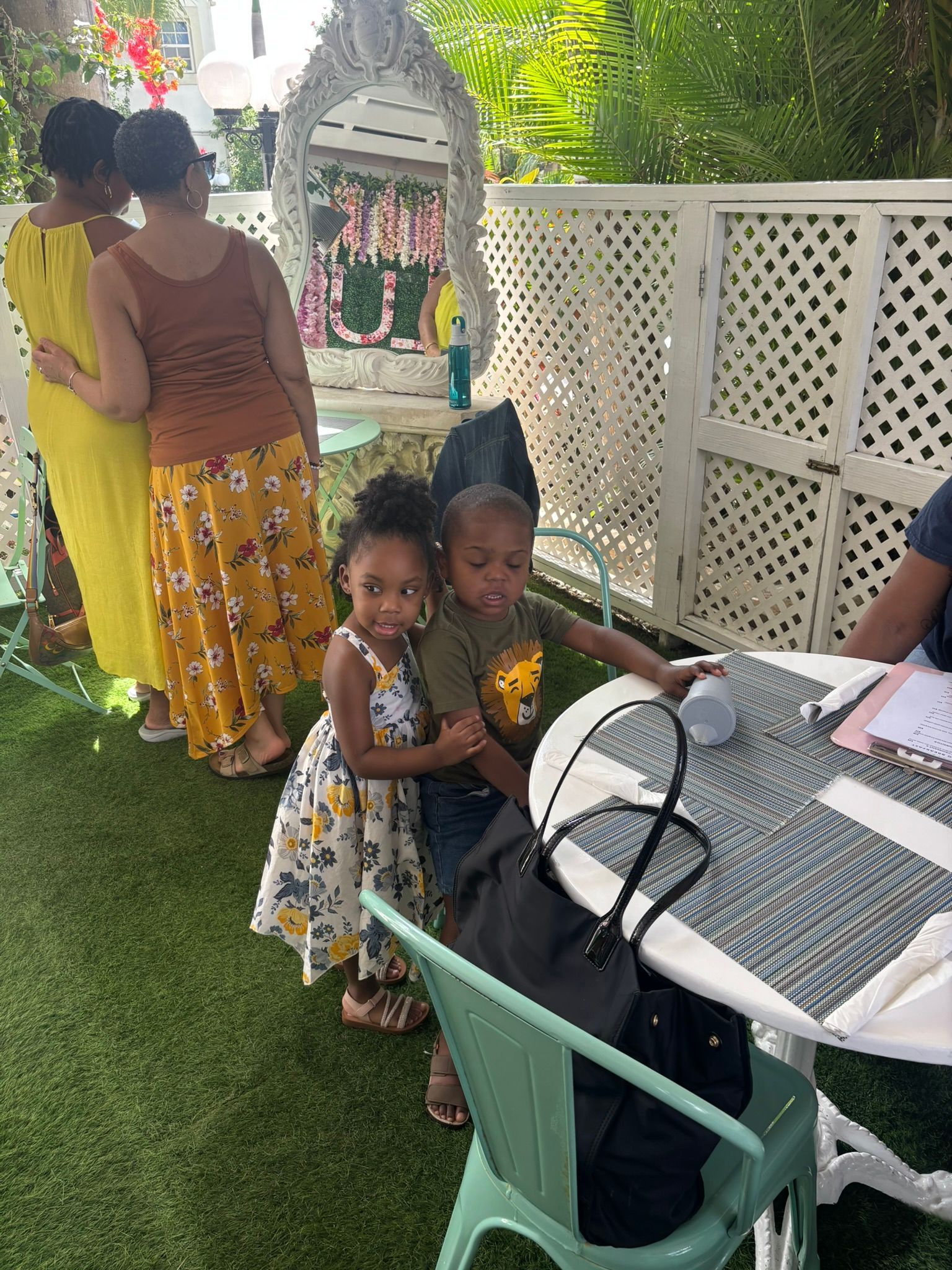 A group of people are standing around a table holding two little girls.