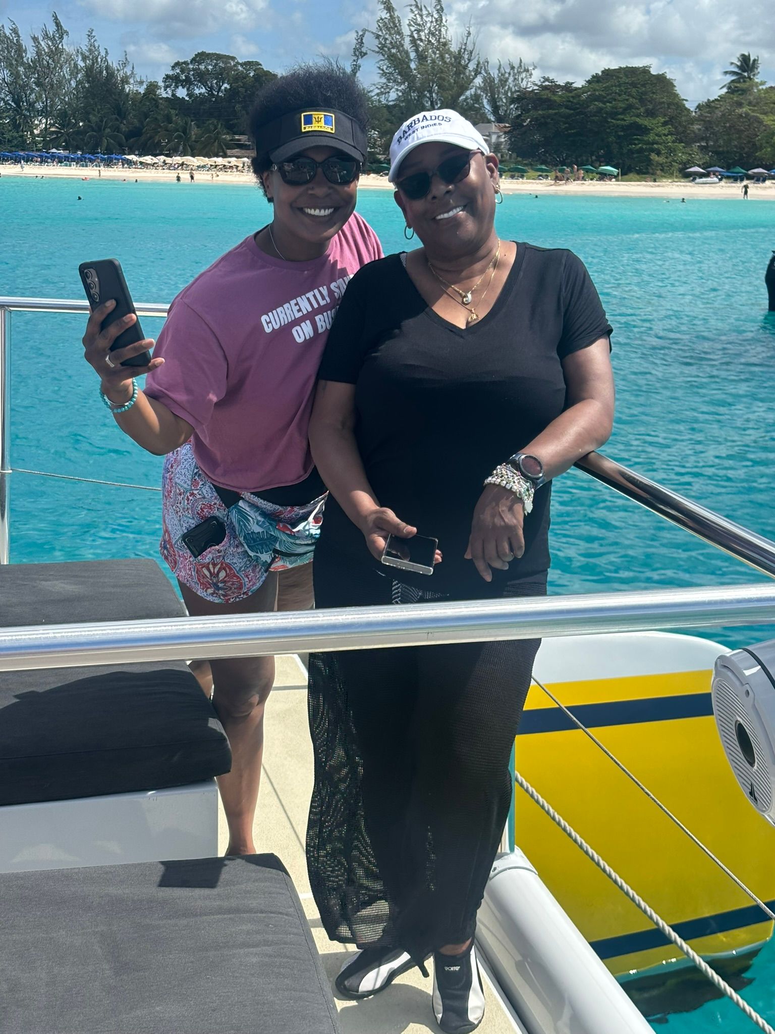Two women are posing for a picture on a boat in the ocean.