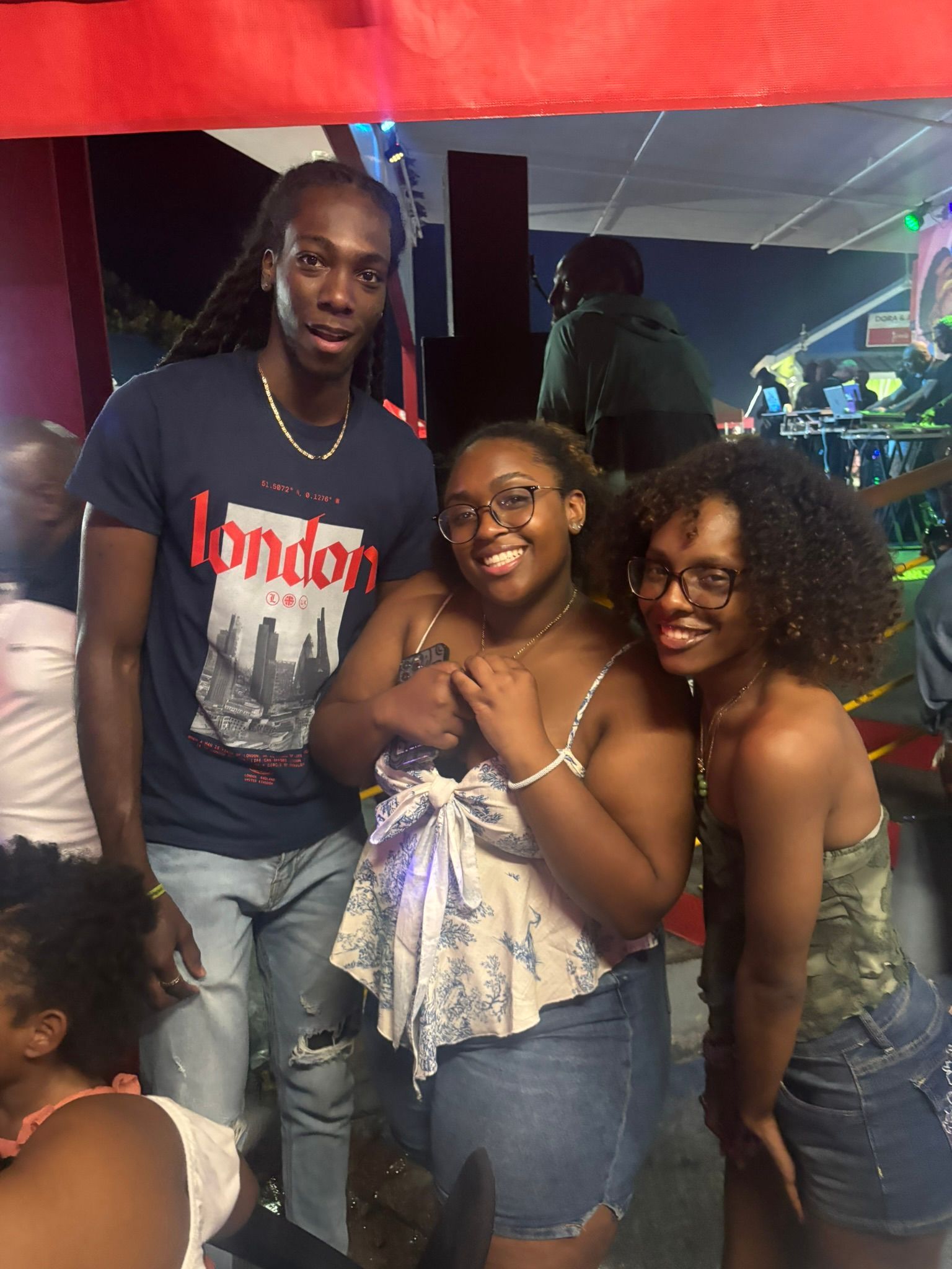 A man wearing a london shirt is posing for a picture with two women