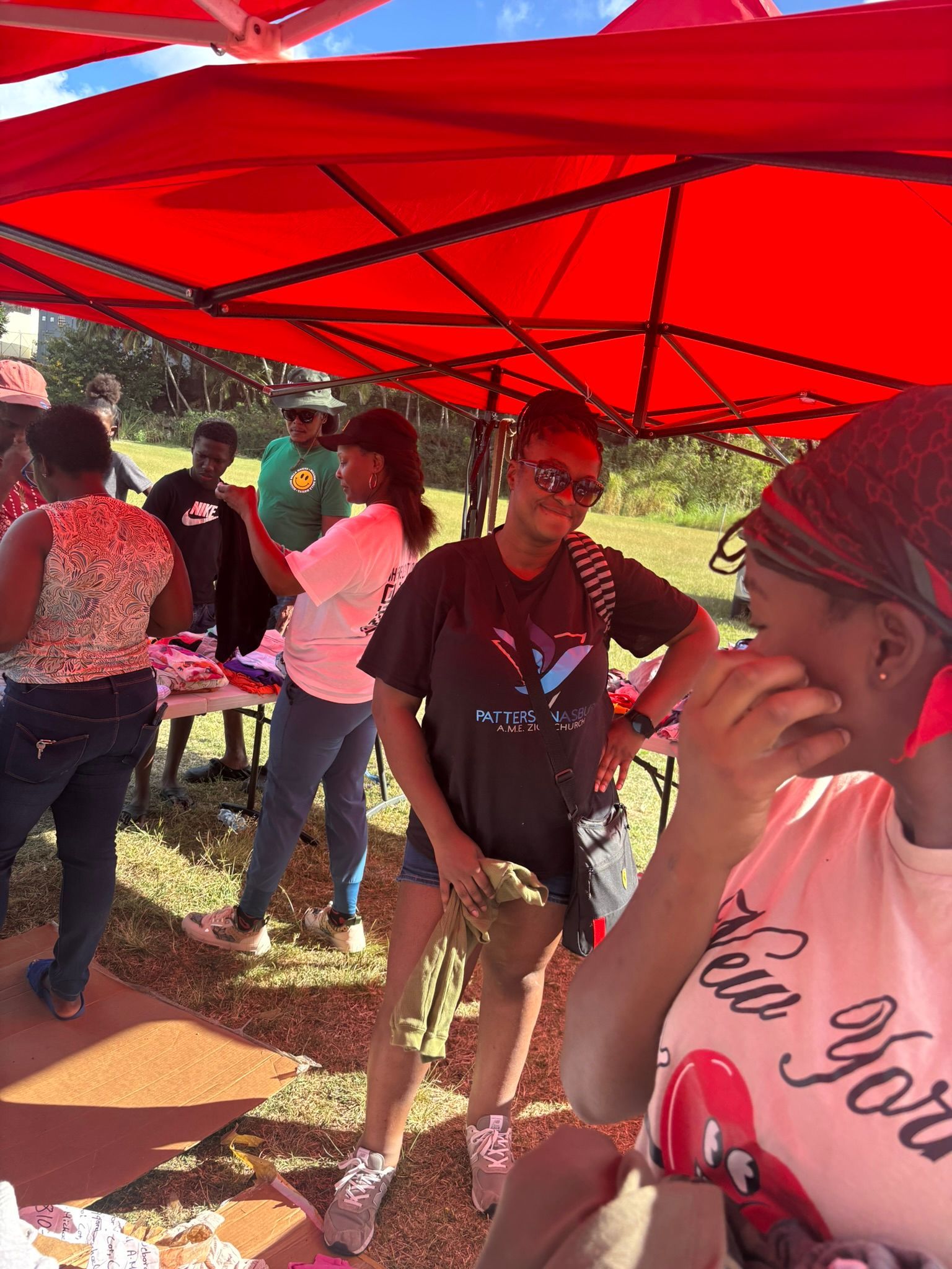 A group of people are standing under red tents.