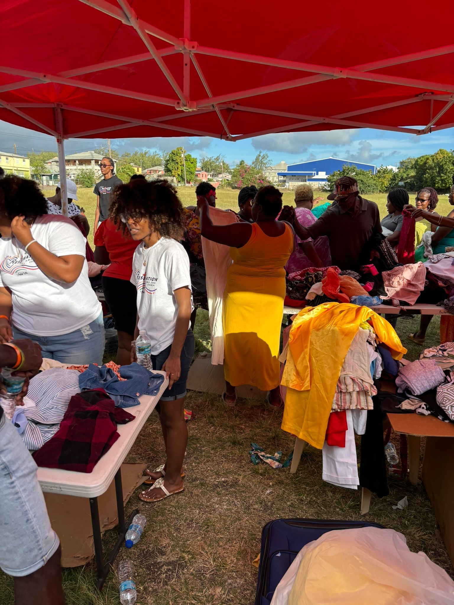 A group of people are standing under a red tent.