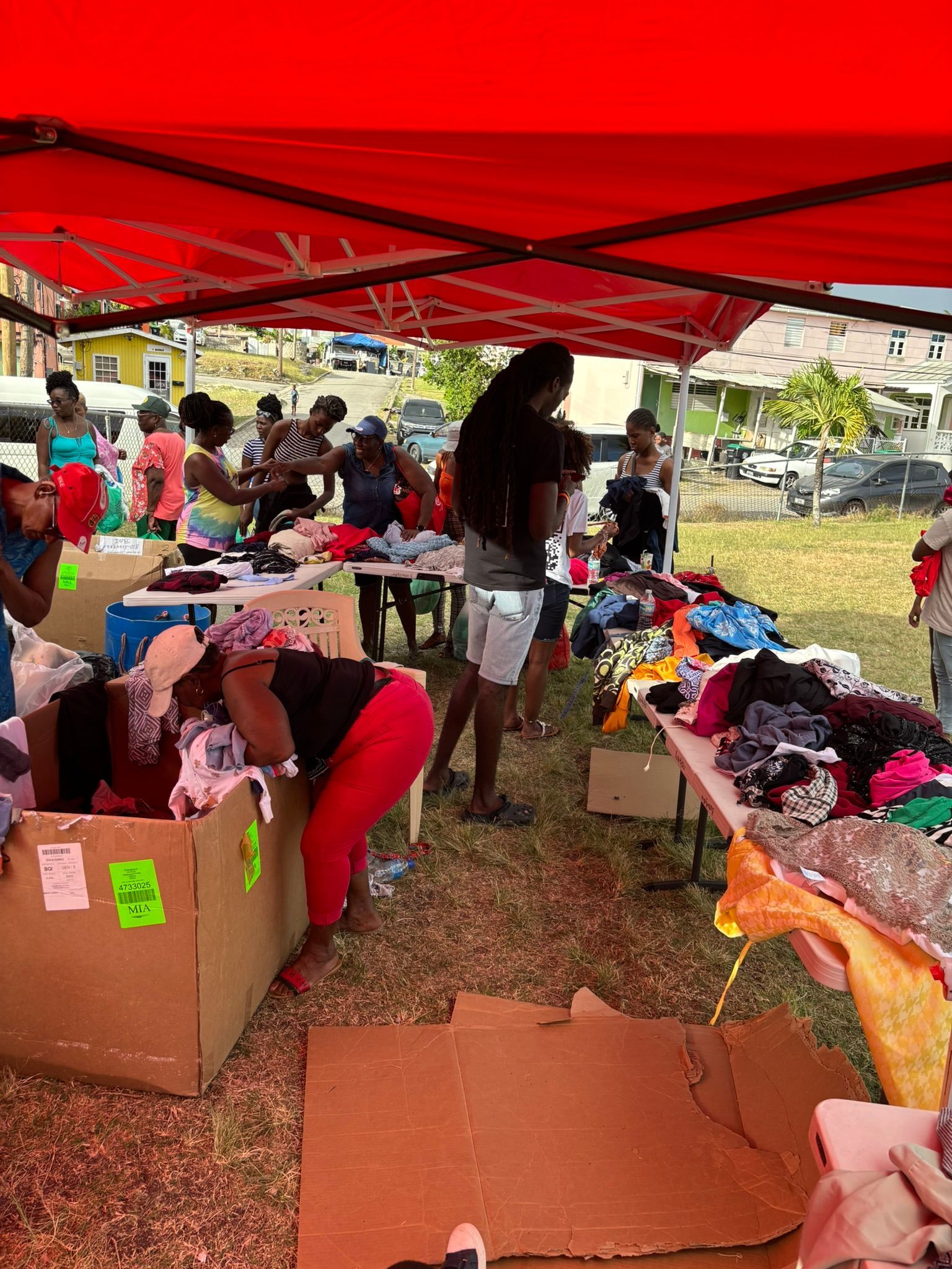 A group of people are standing under a red tent.