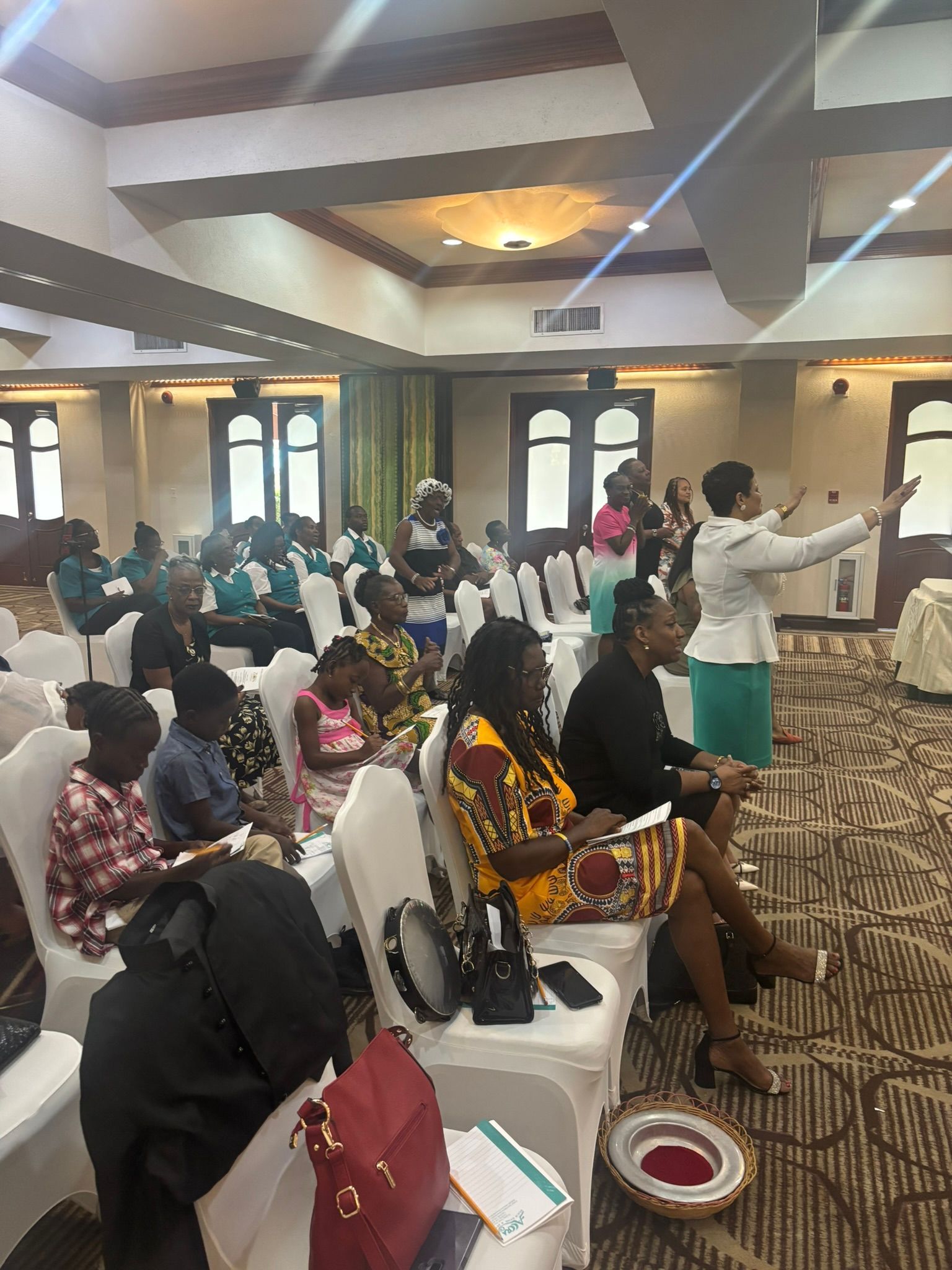 A group of people are sitting in chairs in a large room.