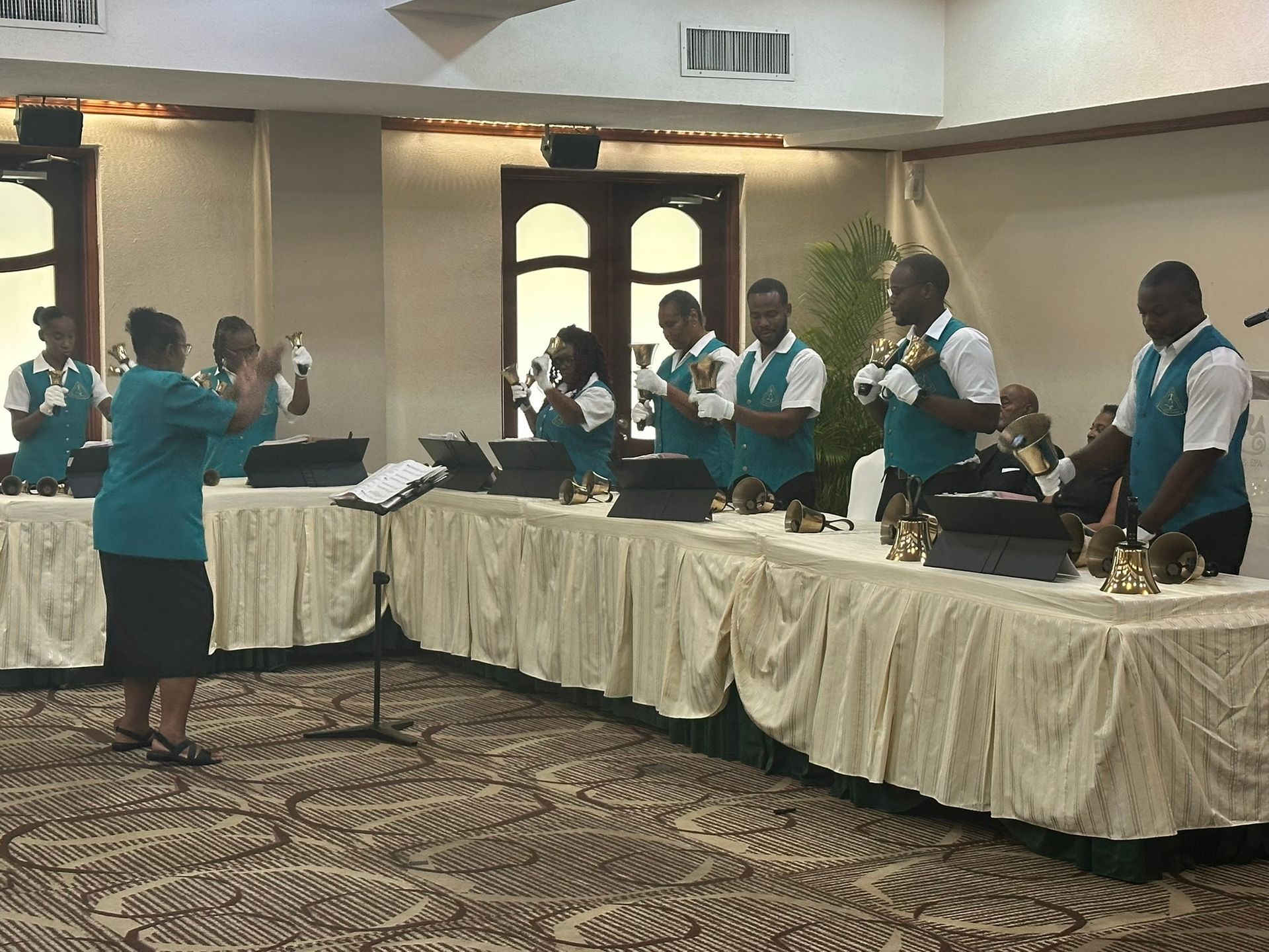 A group of people are playing bells in a room.