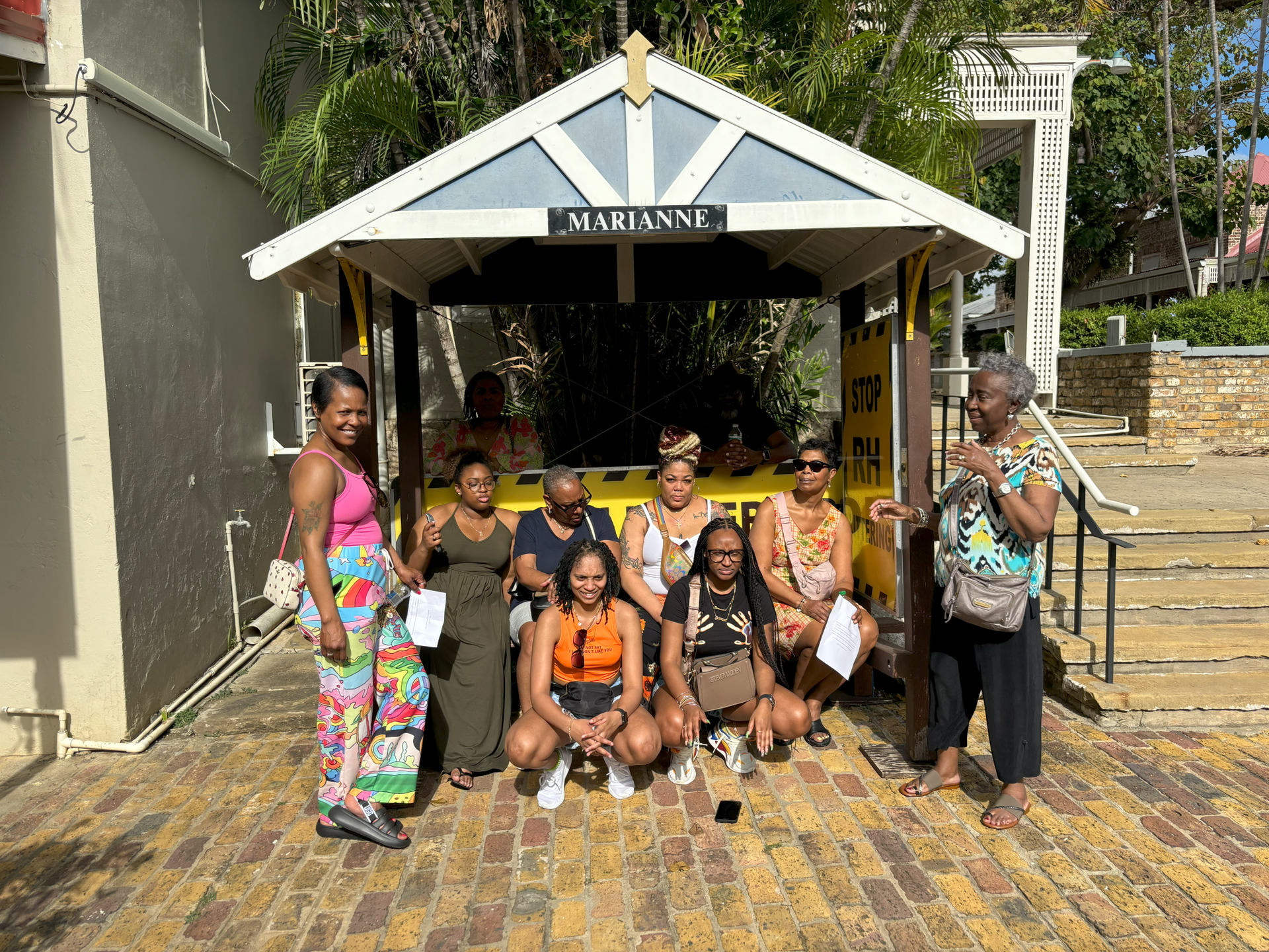 A group of women are posing for a picture in front of a building.