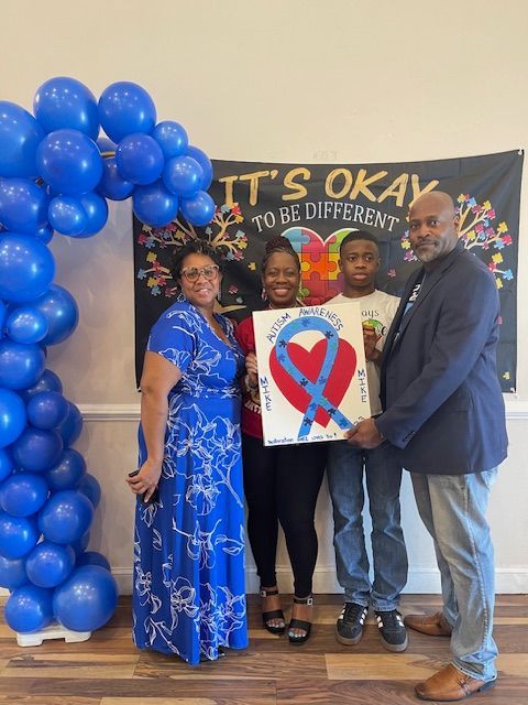 A group of people standing in front of a banner that says it 's okay to be different