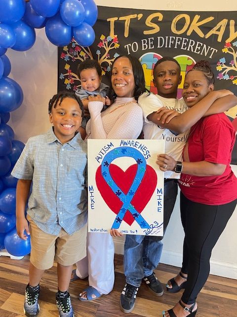 A family holding a sign that says it 's okay to be different