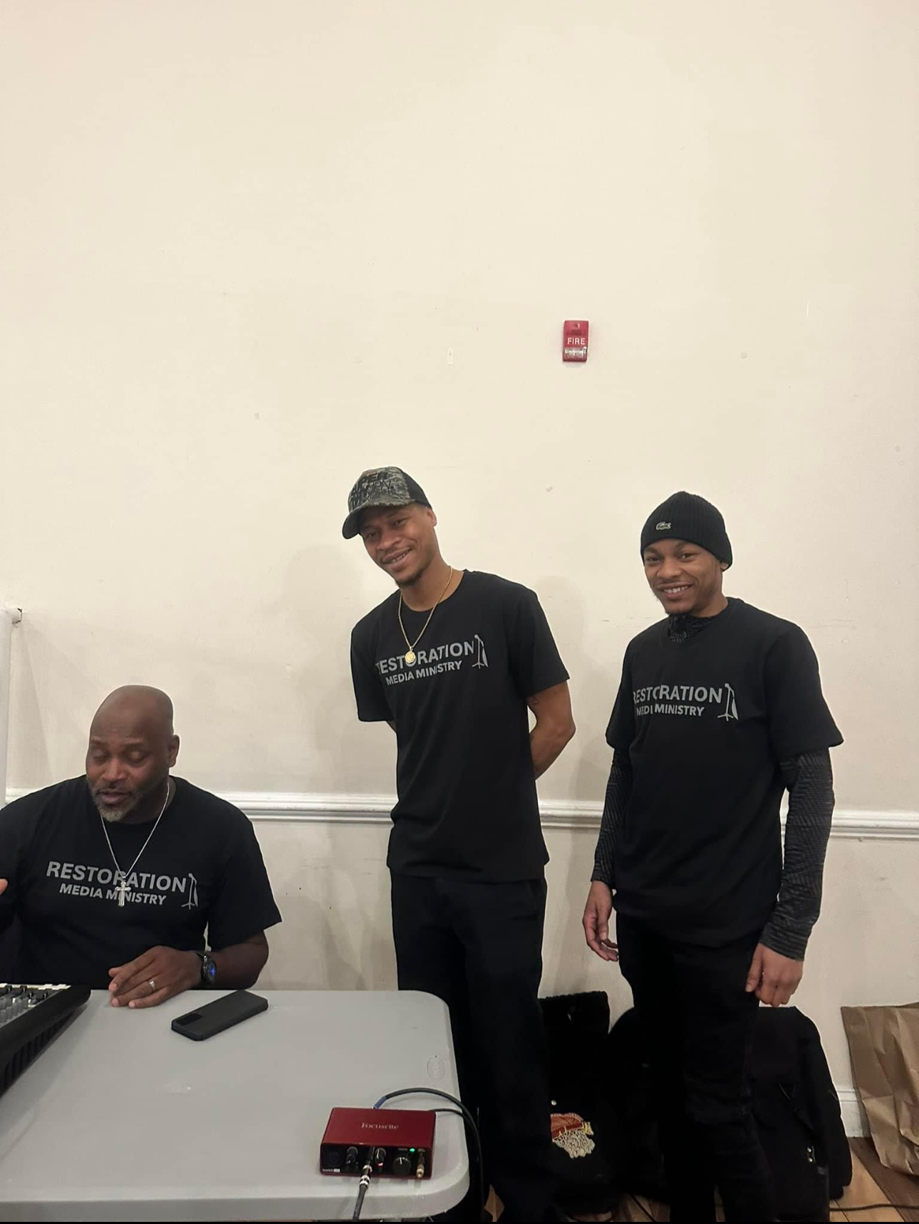 Three men wearing black shirts with the word revolution on them