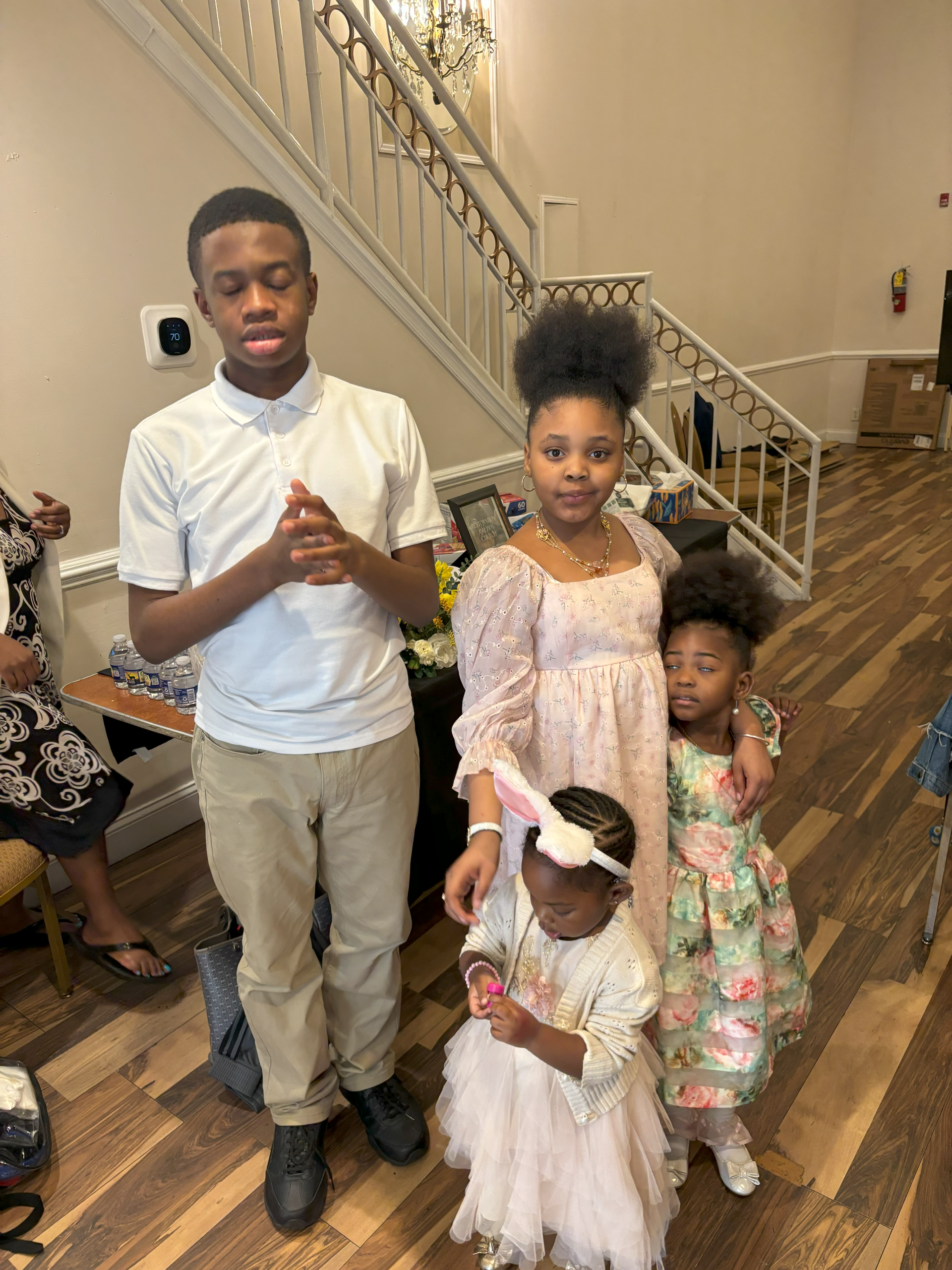 A group of children are standing next to each other in a room.