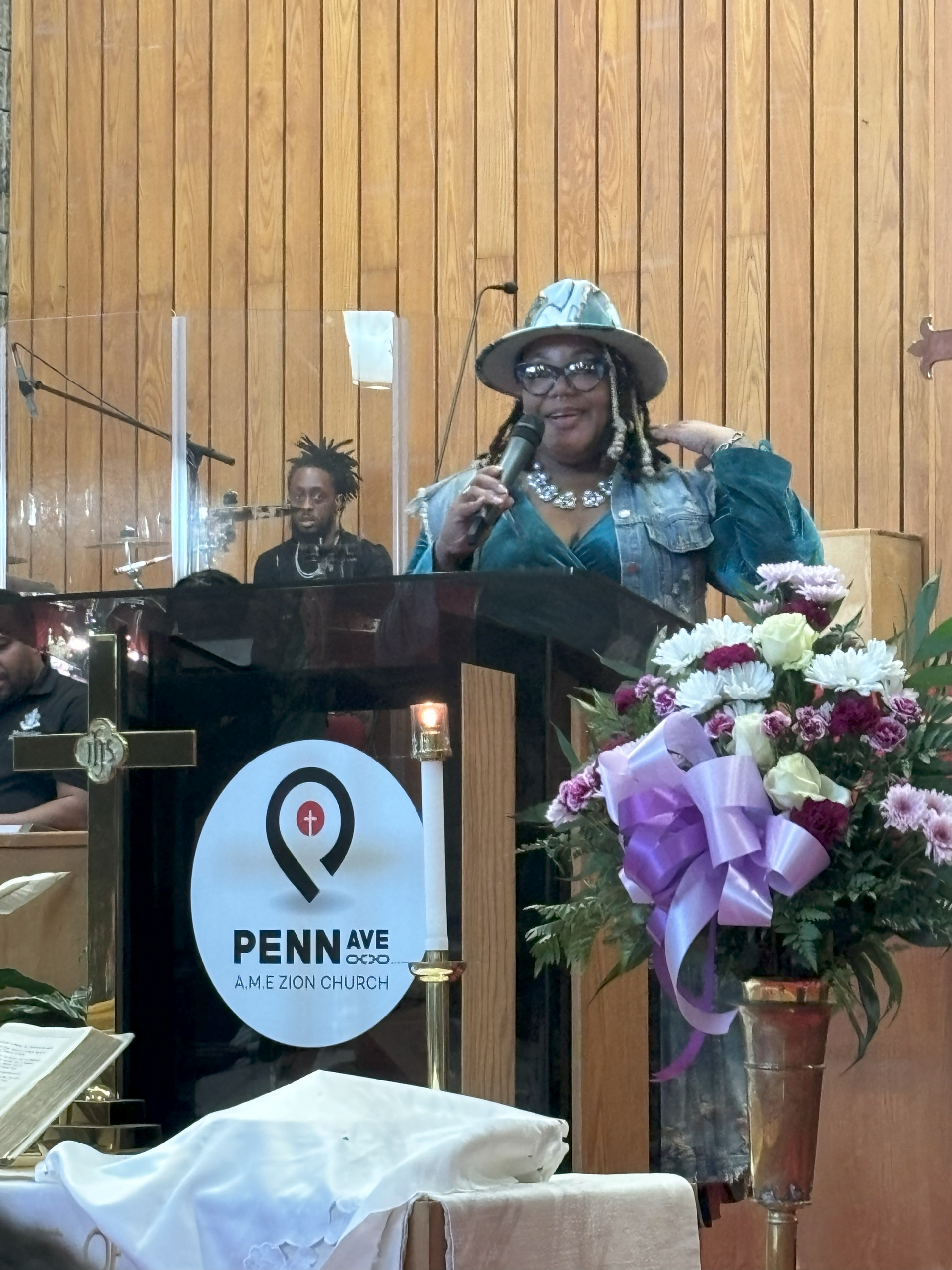 A woman is giving a speech at a podium in a church.