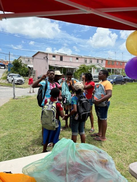 A group of people standing in a field with balloons in the background