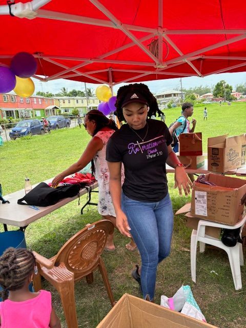 A woman in a black shirt is standing under a red tent