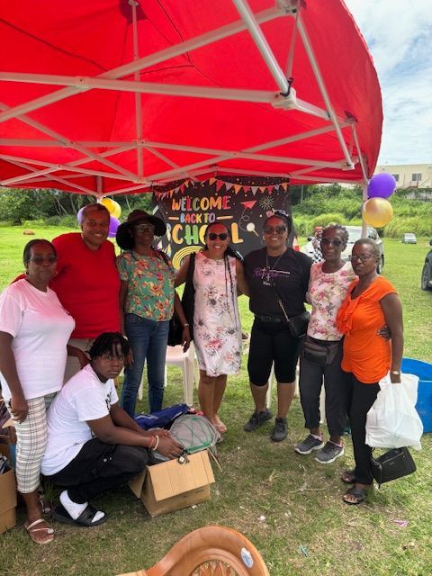 A group of people are posing for a picture under a red tent.