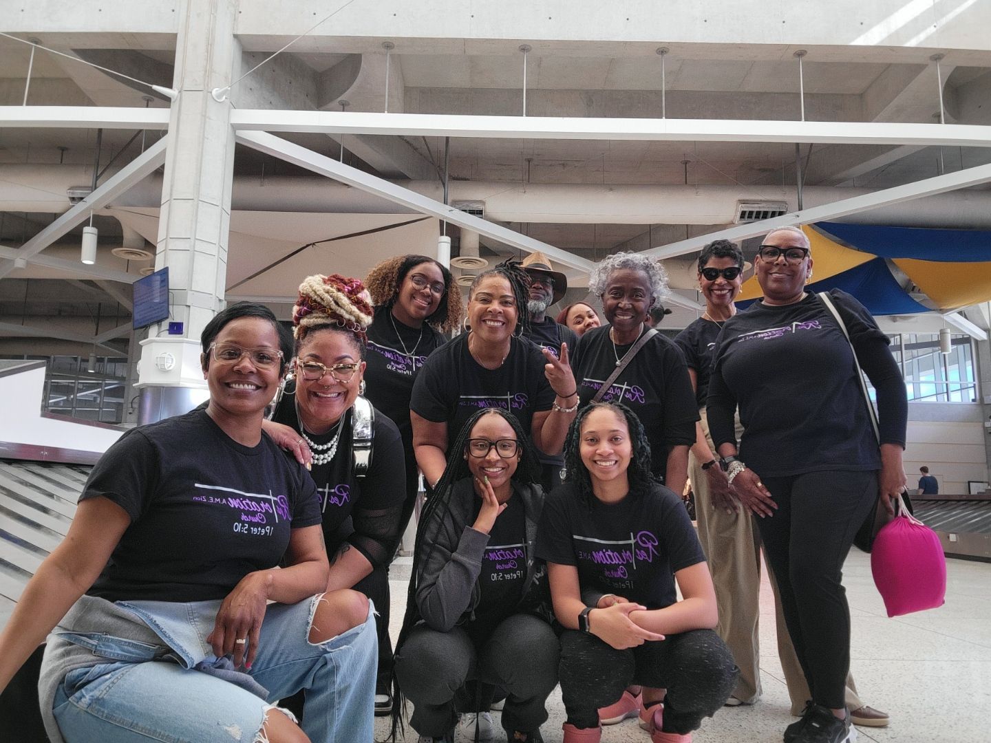 A group of women are posing for a picture in an airport.