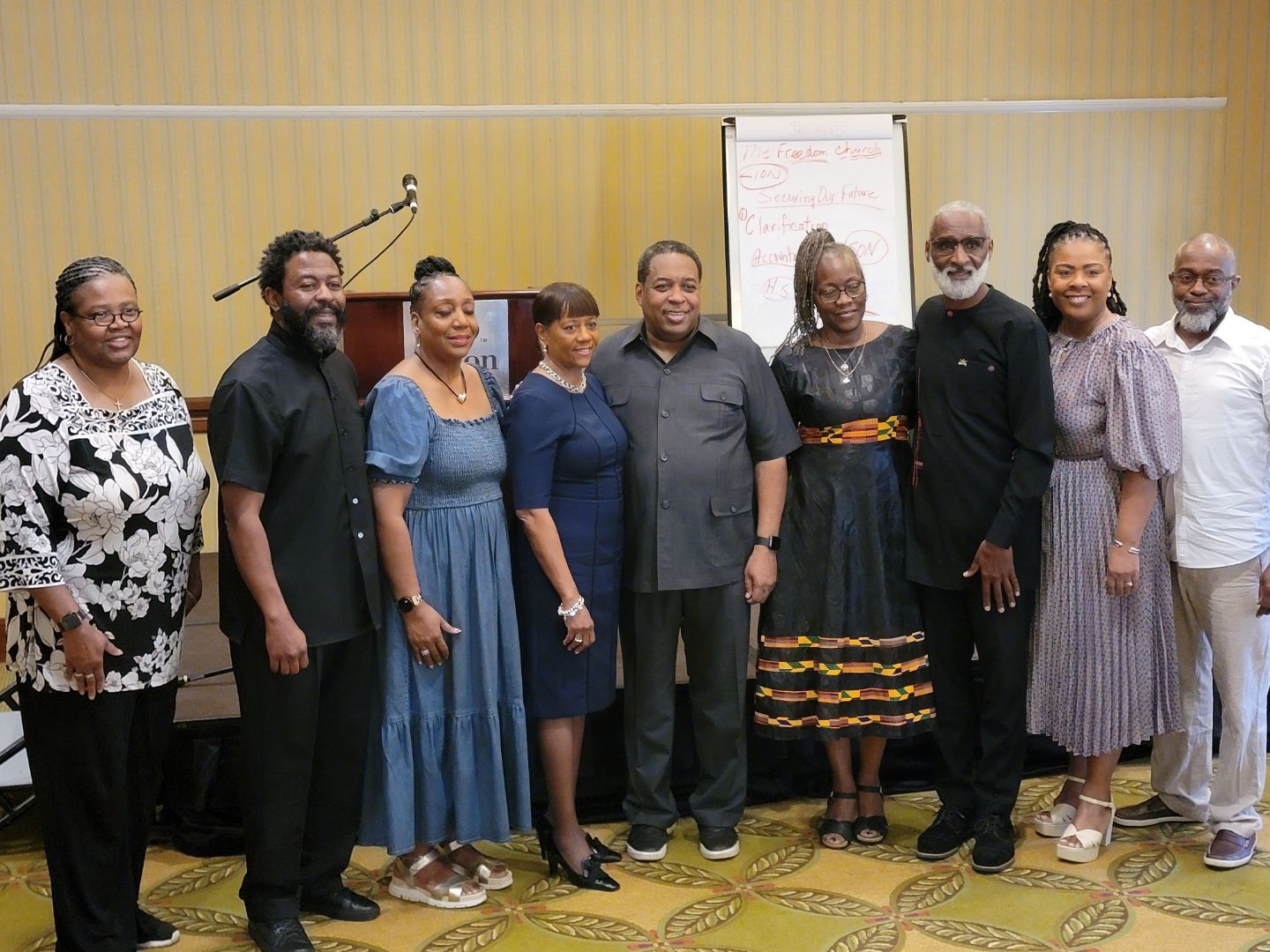 A group of people are posing for a picture in a room.