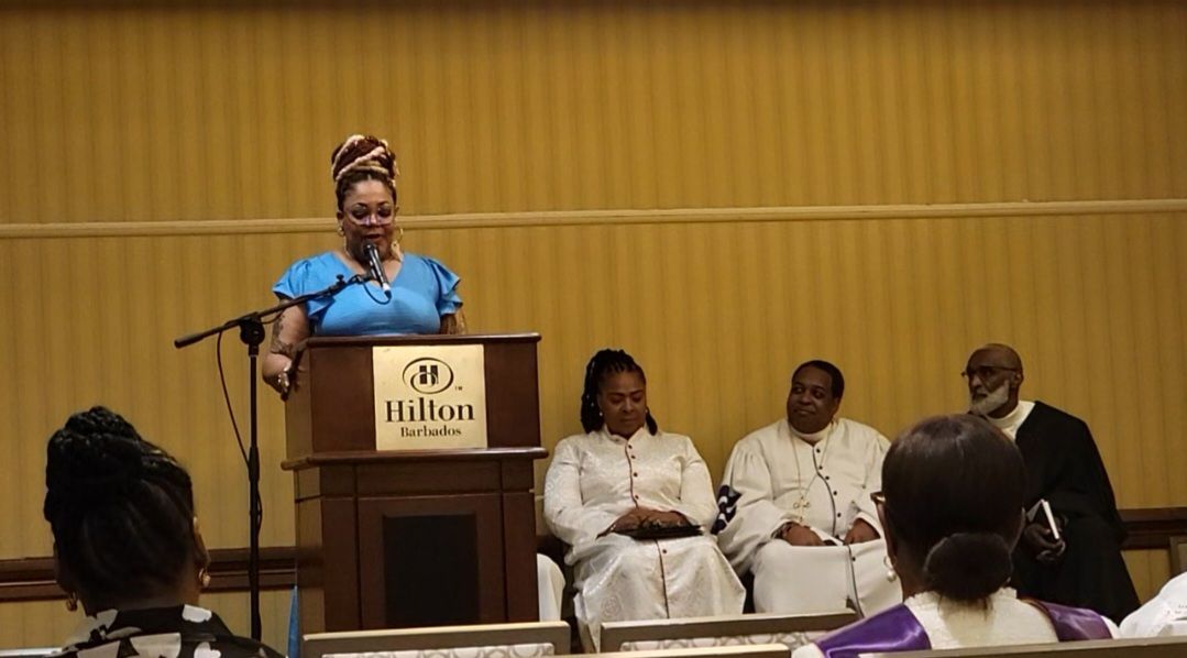 A woman is giving a speech at a podium that says hilton