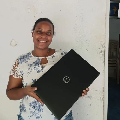 A woman is holding a dell laptop and smiling