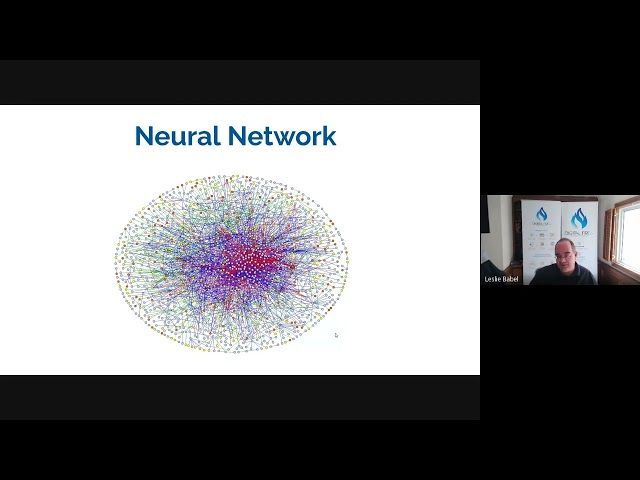 A man is sitting in front of a screen with a diagram of a neural network.