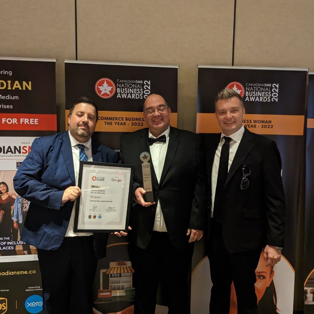 Three men are posing for a picture in front of a sign that says for free