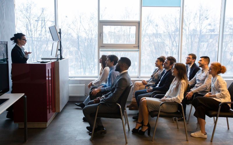 A woman is training the team about cybersecurity. 