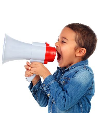 A young boy is holding a megaphone with his mouth open