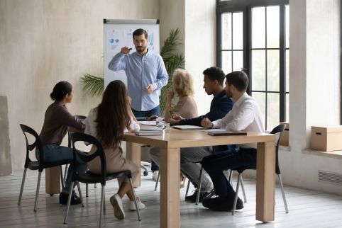 A group of people are sitting around a table having a meeting.