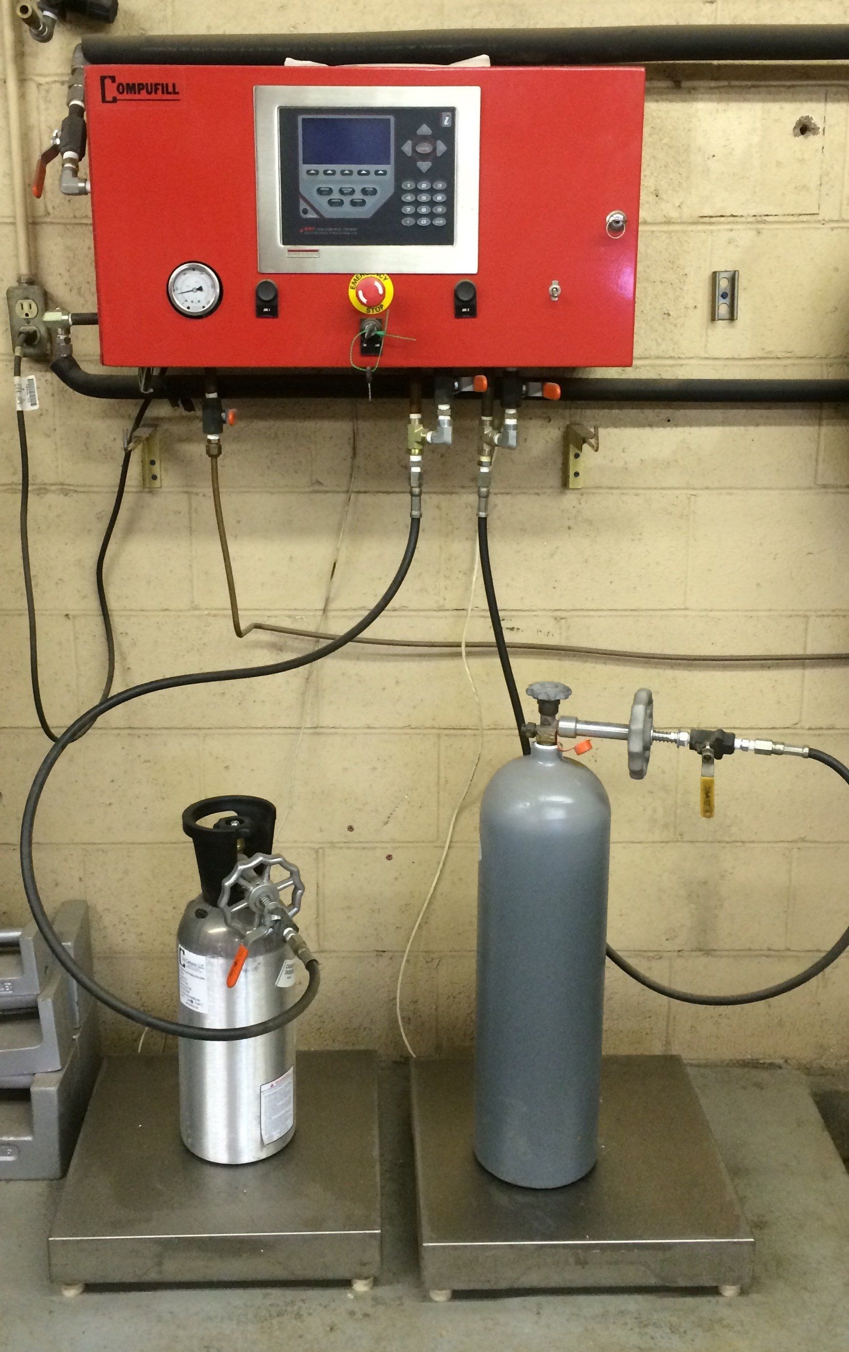 A large aluminum container with a valve, possibly used for fuel or chemicals. Darkened with soot.