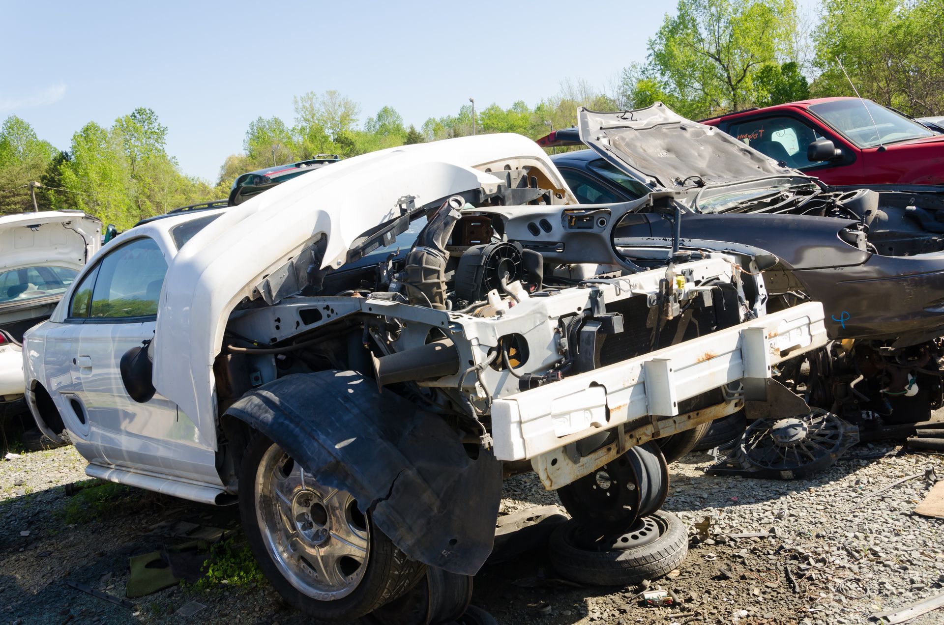Damaged cars lined up at junkyard awaiting recycling and salvage processing. Damaged cars lined up at junkyard awaiting recycling and salvage processing.