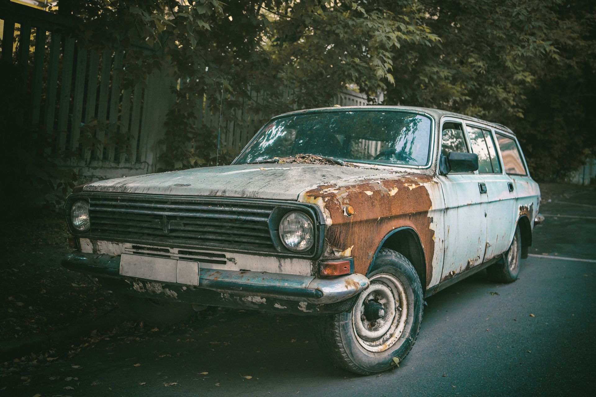 An old rusty car on the side of the road