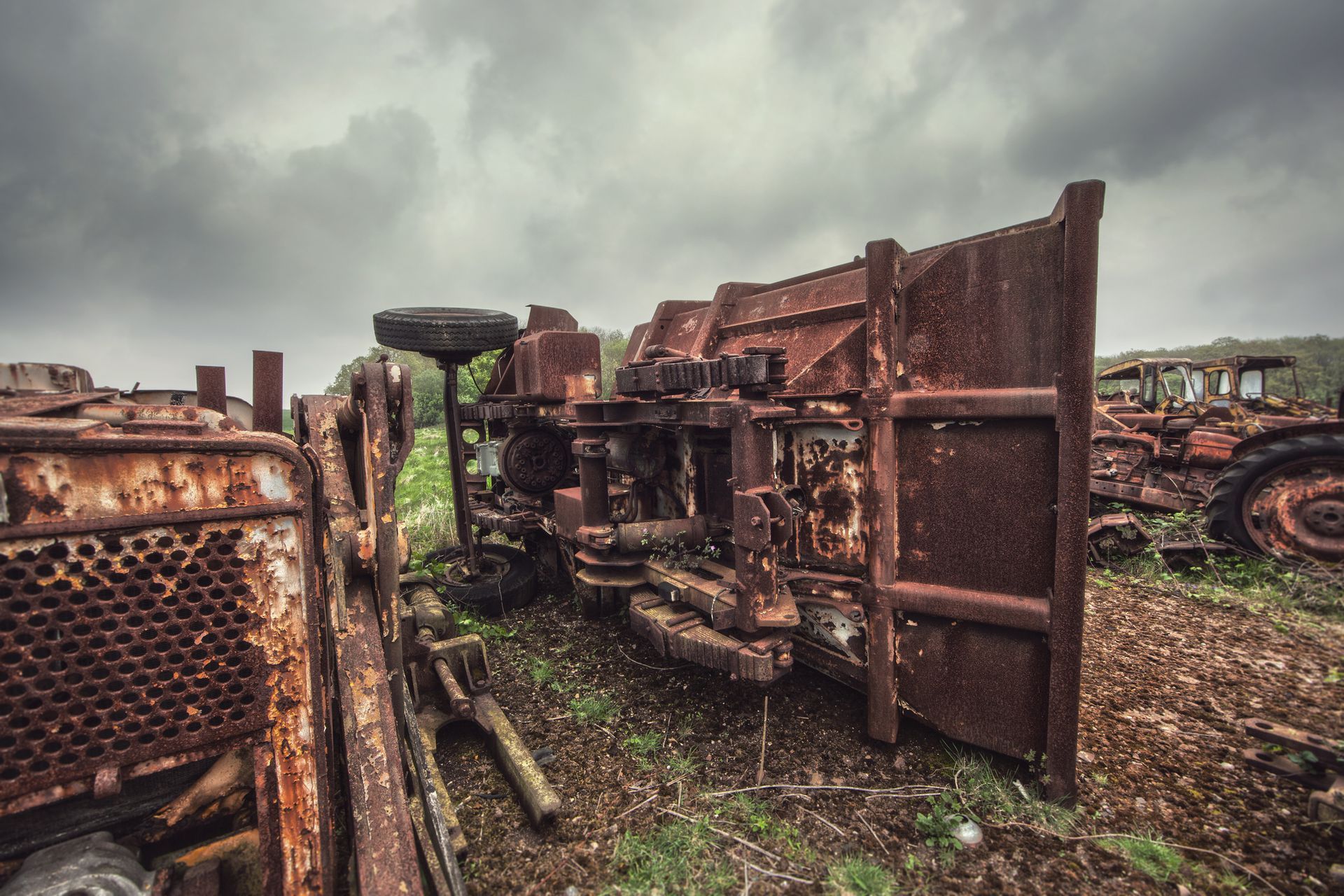A rusty tractor is sitting in the middle of a field.