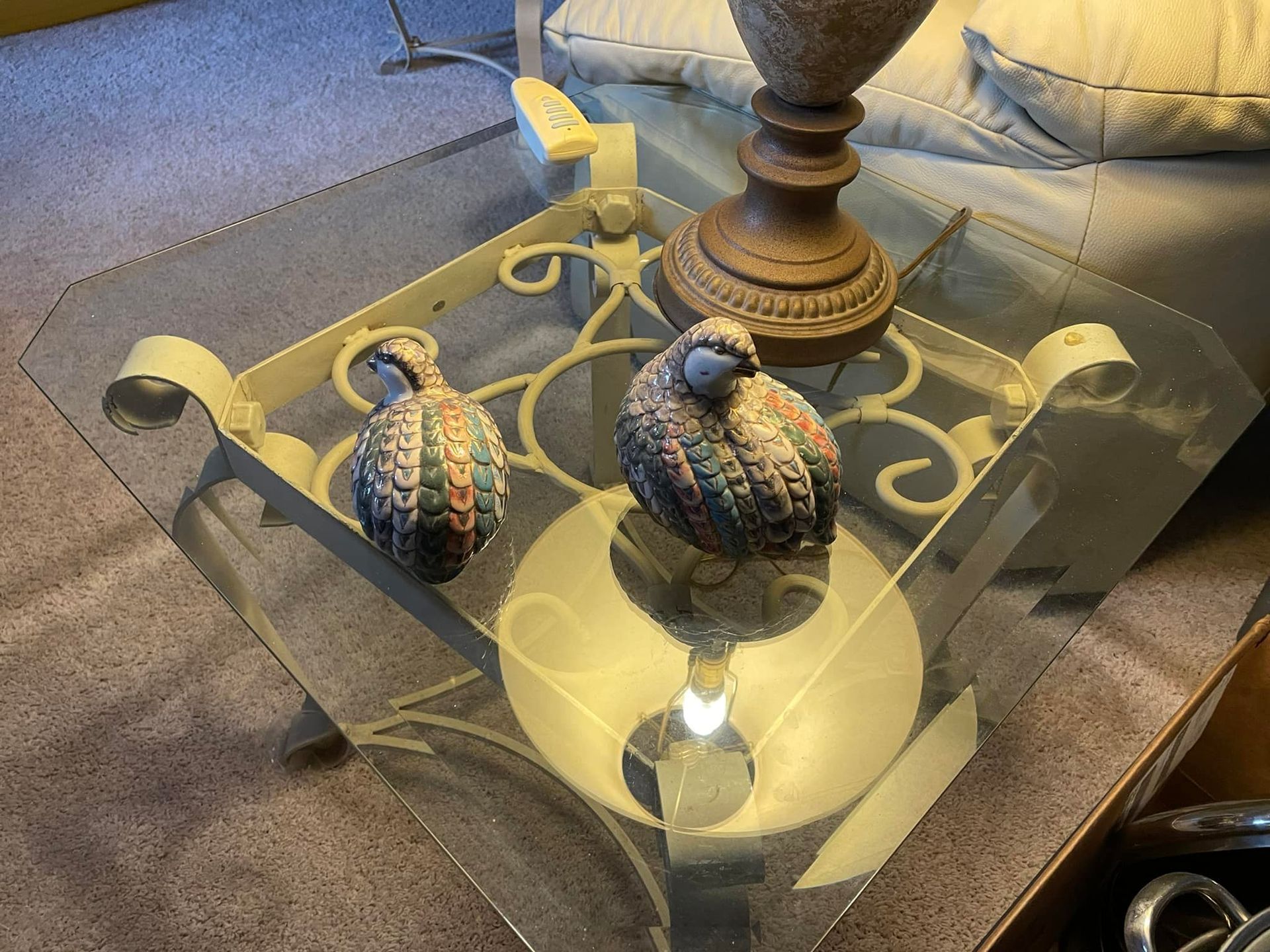 a glass coffee table with two birds on it