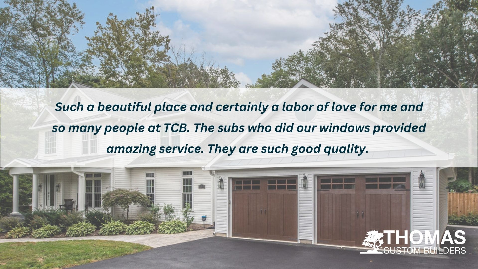 A white house with two garage doors and a quote from thomas custom builders